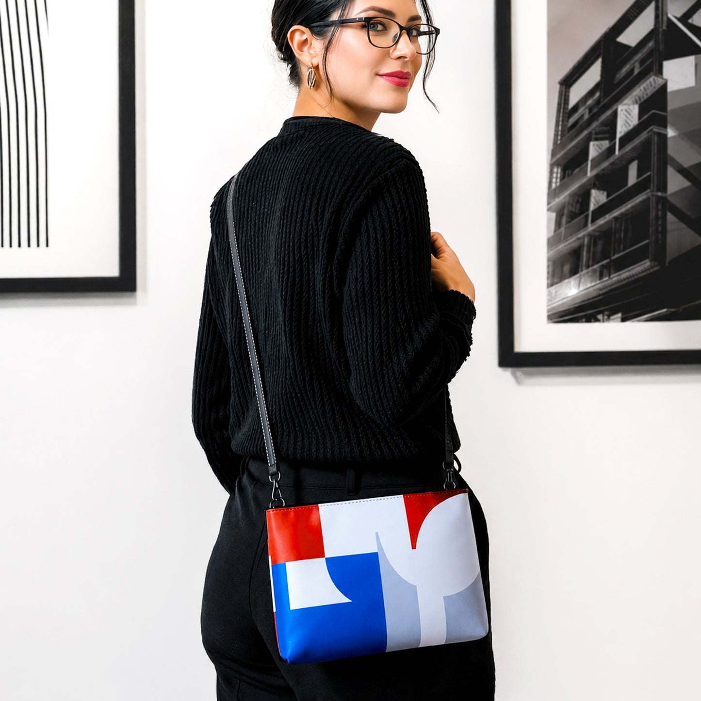 USA CREATES 250 Icon Crossbody Bag, RWB color-block crossbody worn by a woman in all-black against a gallery wall with artwork in editorial portrait