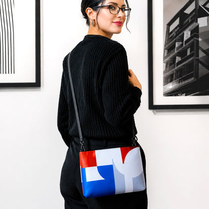 USA CREATES 250 Icon Crossbody Bag, RWB color-block crossbody worn by a woman in all-black against a gallery wall with artwork in editorial portrait