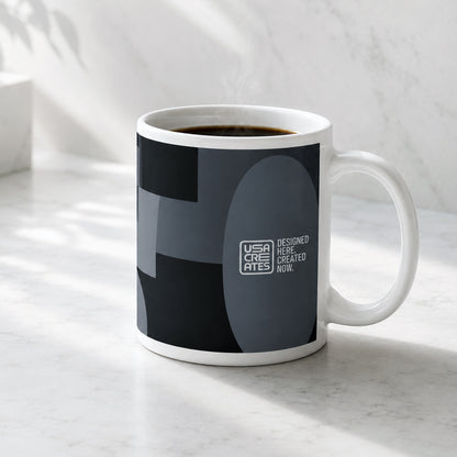 USA CREATES 250 Icon Mug Neutral, dark geometric-print ceramic mug styled on a marble kitchen counter in a modern home setting
